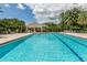 Large community swimming pool with lounge chairs, palm trees and covered seating area for residents at 553 Fallbrook Dr, Venice, FL 34292