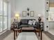 Stylish sitting room featuring a leather couch, side tables with lamps, and a decorative ottoman at 553 Fallbrook Dr, Venice, FL 34292