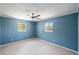 Bedroom with soft blue walls, light wood floors, and two windows that provide natural light at 5992 Osprey Rd, Venice, FL 34293