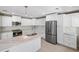 A bright and airy kitchen with stainless steel appliances and an island with marble countertops and sink at 5992 Osprey Rd, Venice, FL 34293