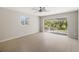 Spacious living room featuring a fan, sliding doors to a lanai, and natural light from a window at 5992 Osprey Rd, Venice, FL 34293