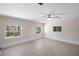 Well-lit living room with large windows, ceiling fan, and sleek wood-look floors at 5992 Osprey Rd, Venice, FL 34293