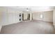 Spacious living area with light wood-look flooring, a laundry closet, and a decorative front door at 5992 Osprey Rd, Venice, FL 34293