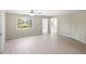 Bright living room with light wood floors, ceiling fan, and a large window that allows natural light at 5992 Osprey Rd, Venice, FL 34293