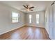Bedroom features wood-look floors, ceiling fan, three windows, and closet at 6422 Otis Rd, North Port, FL 34287