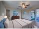 Bedroom featuring wood-look floors, ceiling fan, ensuite bathroom and sliding doors to lanai. VIRTUAL STAGING at 6422 Otis Rd, North Port, FL 34287