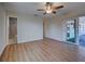 A bright bedroom features wood-look floors, ceiling fan, ensuite bathroom and sliding doors to lanai at 6422 Otis Rd, North Port, FL 34287
