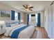Bedroom features wood-look floors, ceiling fan, three windows, and closet. VIRTUAL STAGING at 6422 Otis Rd, North Port, FL 34287