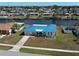 Waterfront home featuring a vibrant blue roof, well manicured lawn, and canal views at 6422 Otis Rd, North Port, FL 34287