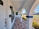 Inviting front porch with arched columns and brick-patterned flooring for a welcoming curb appeal at 6422 Otis Rd, North Port, FL 34287