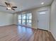 Bright living room with wood-look flooring, a ceiling fan, and large windows for natural light at 6422 Otis Rd, North Port, FL 34287