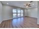 Spacious living room with wood-look flooring, ceiling fan, and large windows offering a bright, open feel at 6422 Otis Rd, North Port, FL 34287