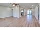 Expansive living room with wood-look floors, a ceiling fan, and easy access to the kitchen and patio at 6422 Otis Rd, North Port, FL 34287
