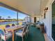 Covered outdoor patio with waterfront views, wicker furniture, dining table, and green carpet at 6422 Otis Rd, North Port, FL 34287