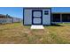 Exterior view of a shed with double doors and a ramp in the backyard at 6422 Otis Rd, North Port, FL 34287