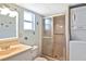 Compact bathroom features a shower, toilet, vanity and stacked washer/dryer at 6451 Keena Ct, North Port, FL 34287