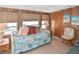 Comfortable bedroom featuring natural light, wood paneling, and a cozy daybed with colorful pillows at 6451 Keena Ct, North Port, FL 34287