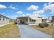 Charming home exterior with a manicured lawn and a driveway under a beautiful blue sky and clouds at 6451 Keena Ct, North Port, FL 34287