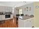 Charming kitchen featuring white cabinetry, an island with seating, and wood-look flooring at 6451 Keena Ct, North Port, FL 34287