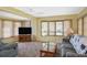 This living room features natural light, a ceiling fan, and comfortable seating at 6451 Keena Ct, North Port, FL 34287