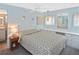 Serene main bedroom with light blue walls, double windows, and built in storage solutions at 6451 Keena Ct, North Port, FL 34287