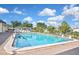 Bright swimming pool is surrounded by green spaces and places for sun bathing with community seating at 6451 Keena Ct, North Port, FL 34287