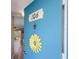 Blue front door to condo 106 features a charming yellow flower and an open doorway to the living room at 649 Tamiami S Trl # 106, Venice, FL 34285