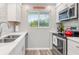 Bright kitchen featuring stainless steel appliances and white cabinetry at 649 Tamiami S Trl # 106, Venice, FL 34285