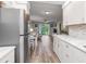 Modern kitchen open to the living area with stainless steel appliances and wood flooring at 649 Tamiami S Trl # 106, Venice, FL 34285