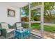 Cozy screened-in patio features wicker furniture and a view of the landscaped backyard at 649 Tamiami S Trl # 106, Venice, FL 34285