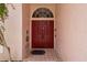 Inviting entryway features a double red door, tiled floor, and decorative landscaping at 6507 Drewry'S Blf, Bradenton, FL 34203