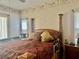 Traditional main bedroom with a four-poster bed, patterned bedding, and warm lighting at 6507 Drewry'S Blf, Bradenton, FL 34203