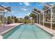 Relaxing screened in pool with fountain feature surrounded by tropical plants, adjacent to lush landscaping at 6507 Drewry'S Blf, Bradenton, FL 34203