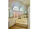 Relaxing primary bathroom featuring a soaking tub under elegant arched windows and shower at 6507 Drewry'S Blf, Bradenton, FL 34203