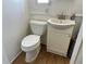 This bathroom has a toilet, a vanity with a sink, and paneled walls at 6765 Laurel Ct, North Port, FL 34287
