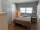 This bedroom features a queen-size bed, and a window with mini-blinds at 6765 Laurel Ct, North Port, FL 34287