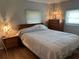 This bedroom features a queen-sized bed, two windows and matching bedside lamps at 6765 Laurel Ct, North Port, FL 34287