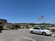 Exterior of a community building with a white car parked in front and the American flag waving nearby at 6765 Laurel Ct, North Port, FL 34287
