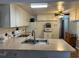 Bright kitchen features a large sink, white cabinets, and appliances at 6765 Laurel Ct, North Port, FL 34287