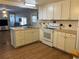 This kitchen has a laminate floor, white cabinets and appliances, with an island at 6765 Laurel Ct, North Port, FL 34287