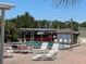 Exterior image of the pool area with lounge chairs and nearby palm trees, inviting relaxation at 6765 Laurel Ct, North Port, FL 34287