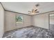 Bedroom featuring gray wood-look floors, a ceiling fan, and a sunlit window at 6803 Amoko Ct, North Port, FL 34287
