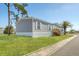 Charming gray single-story home with white trim, manicured lawn, and a wooden porch at 6803 Amoko Ct, North Port, FL 34287