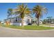 View of home at corner lot with mature trees, carport, and well-kept lawn at 6803 Amoko Ct, North Port, FL 34287