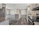 Open kitchen boasts an island, stainless appliances, and modern wood-look flooring, flowing into living area at 6803 Amoko Ct, North Port, FL 34287