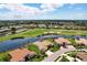 Stunning aerial view of a tile roof home on a golf course with water and lush landscaping in a vibrant community at 872 Macaw Cir, Venice, FL 34285