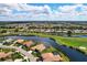 An aerial view shows a luxurious home nestled by the water and a lush golf course at 872 Macaw Cir, Venice, FL 34285