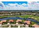 An aerial view shows a home surrounded by lush golf course and serene lakes at 872 Macaw Cir, Venice, FL 34285