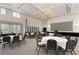 This spacious ballroom features round tables with white linens, and a beautiful chandelier at 872 Macaw Cir, Venice, FL 34285