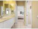 Well-lit bathroom offering dual sinks, tile floors, and views of an adjacent bedroom through a doorway at 872 Macaw Cir, Venice, FL 34285